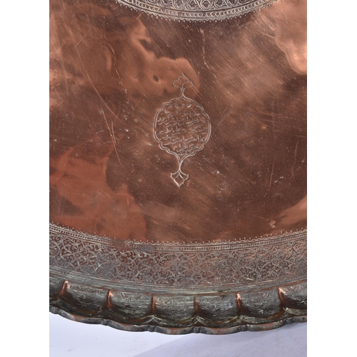 3191 - A large Middle eastern copper tray etched with Tugra and script and hammered scalloped rim 72 cm dia... 
