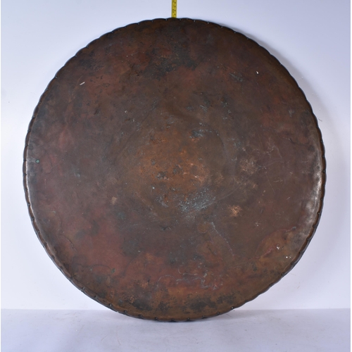 3191 - A large Middle eastern copper tray etched with Tugra and script and hammered scalloped rim 72 cm dia... 