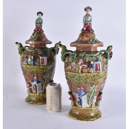 103 - A RARE LARGE PAIR OF 19TH CENTURY MAJOLICA VASES AND COVERS unusually formed with Chinese figures an... 