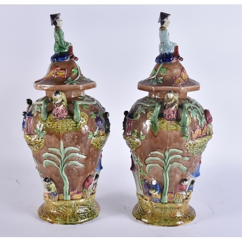 103 - A RARE LARGE PAIR OF 19TH CENTURY MAJOLICA VASES AND COVERS unusually formed with Chinese figures an... 