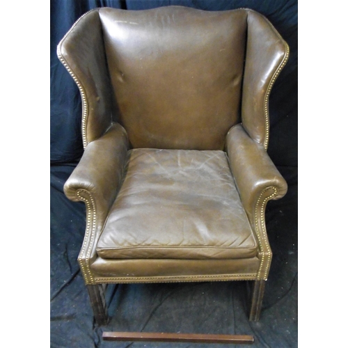 70 - LARGE LEATHER ARMCHAIR WITH BRASS STUD TO WING AND ARM (BASE STRETCHER COME AWAY BUT NOT BROKEN)