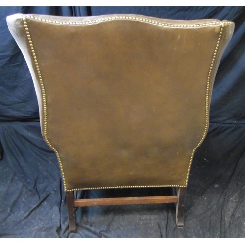 70 - LARGE LEATHER ARMCHAIR WITH BRASS STUD TO WING AND ARM (BASE STRETCHER COME AWAY BUT NOT BROKEN)