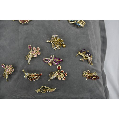 340 - QUANTITY OF COSTUME JEWELLERY BROOCHES ON CUSHION AND QUANTITY OF PIN BADGES