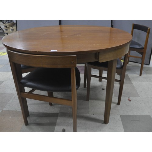 282 - MID CENTURY TEAK CIRCULAR DINING TABLE WITH 4 CHAIRS IN BLACK VINYL - SCRATCHES TO TABLE TOP, SOME C... 