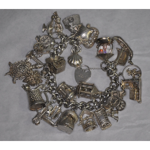 134 - SILVER CHARM BRACELET WITH 26 CHARMS AND HEART SHAPED LOCK AND SAFETY CHAIN 149.4g