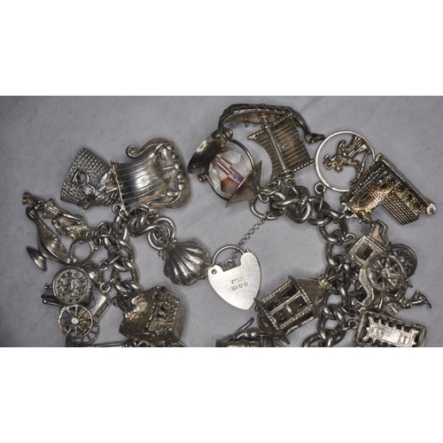 134 - SILVER CHARM BRACELET WITH 26 CHARMS AND HEART SHAPED LOCK AND SAFETY CHAIN 149.4g