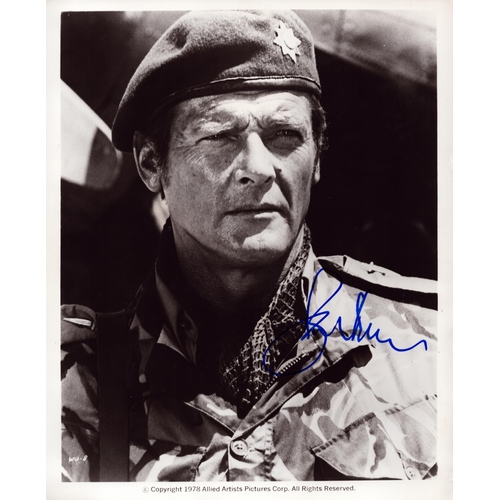 74 - Roger Moore signed 10x8inch black and white photo.