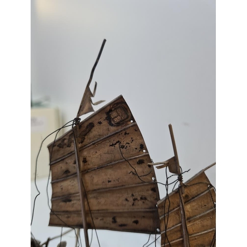 111 - Wang Hing; a silver boat, Hong Kong, with three sails, Cannons on deck and a carved wooden base. Fig... 