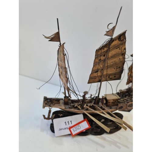 111 - Wang Hing; a silver boat, Hong Kong, with three sails, Cannons on deck and a carved wooden base. Fig... 