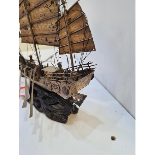 111 - Wang Hing; a silver boat, Hong Kong, with three sails, Cannons on deck and a carved wooden base. Fig... 