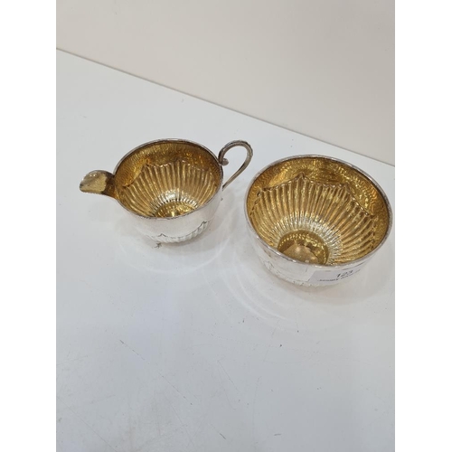 123 - A silver Edwardian Mappin and Webb sugar bowl and creamer, with gilt interior and half reeded body. ... 