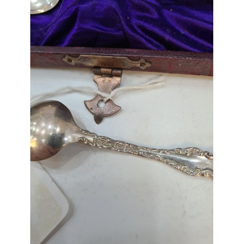 129 - A cased set of 12 Sterling silver teaspoons with embossed scroll bordered handles. Cased napkin ring... 