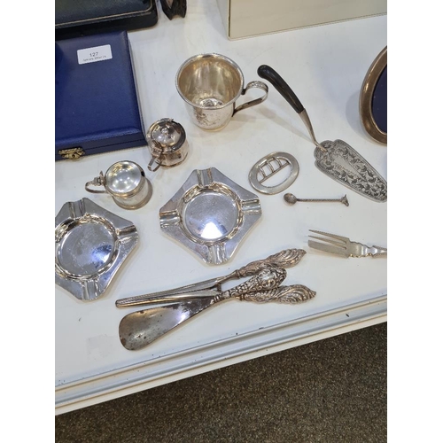 136 - A mixed silver lot comprising ornate embossed glove stretchers, shoe horn, two heavy silver ashtrays... 