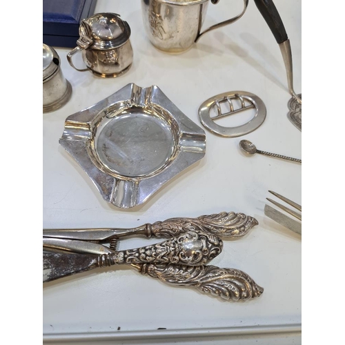 136 - A mixed silver lot comprising ornate embossed glove stretchers, shoe horn, two heavy silver ashtrays... 