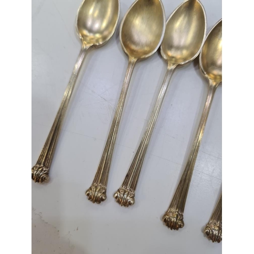 141 - An attractive set of six silver gilt teaspoons having scroll terminals. Hallmarked London 1922-24 He... 