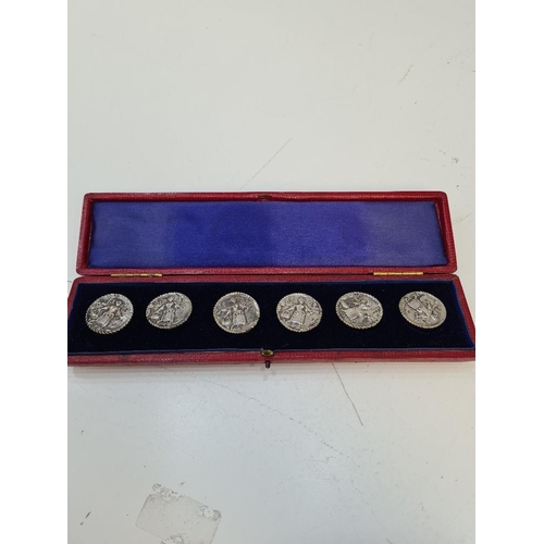 18 - A cased set of silver Dutch buttons having embossed details of a figure. Reeded border and attractiv... 