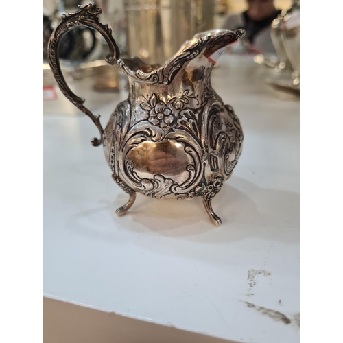 49 - A Continental silver jug, very pretty in style, rim floreated embossed details and figures. Scroll h... 