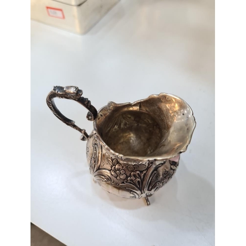 49 - A Continental silver jug, very pretty in style, rim floreated embossed details and figures. Scroll h... 