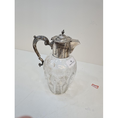 58 - A silver topped pretty cut glass Claret jug, having silver acanthus leaf scroll handle and flower em... 