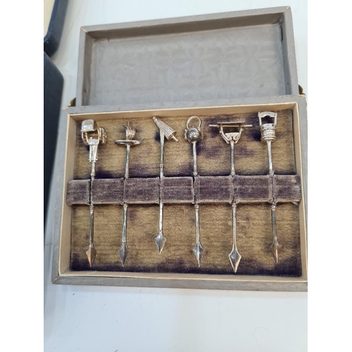 89 - A cased set of decorative white metal cocktail sticks having various terminals including a boat, wel... 