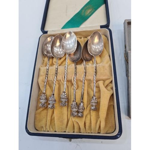 89 - A cased set of decorative white metal cocktail sticks having various terminals including a boat, wel... 