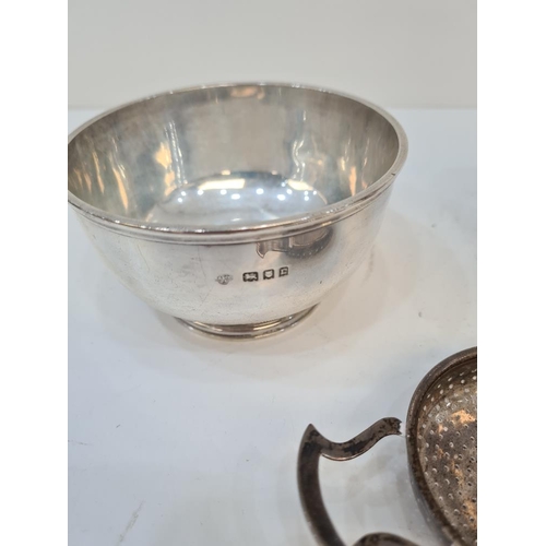 8A - A heavy silver sugar bowl, a silver milk jug with acanthus leaf handle, and a silver tea strainer, b... 