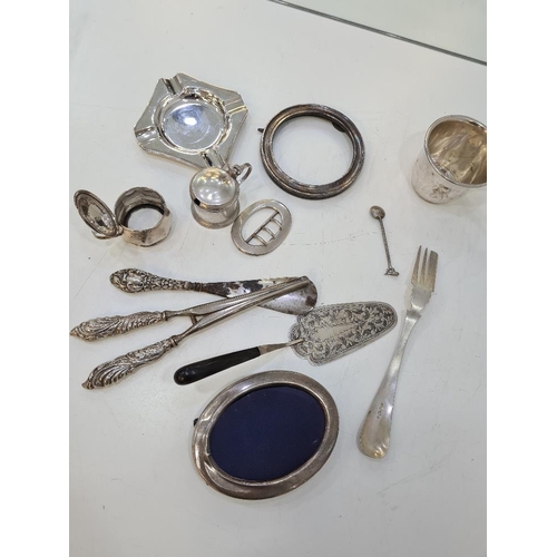 1126 - A mixed silver lot comprising ornate embossed glove stretchers, shoe horn, two heavy silver ashtrays... 