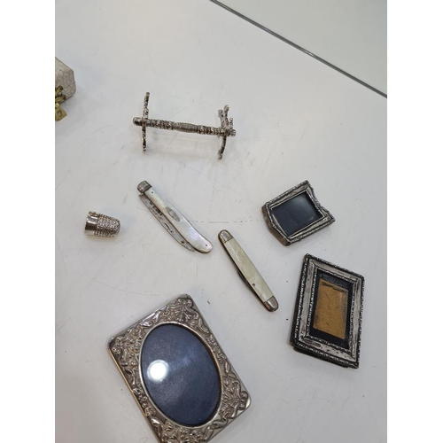 1127 - A mixed lot of silver and plated items to include a cased thimble, miniature silver frames, penknive... 