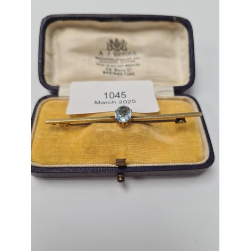 1045 - 15ct yellow gold bar brooch with central oval aquamarine, brooch marked 15ct, in fitted brown leathe... 