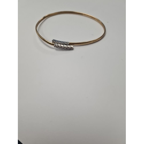 1052 - 9ct yellow gold open bangle, the ends each set with 6 cubic zirconias, marked 9ct, approx 3.9g