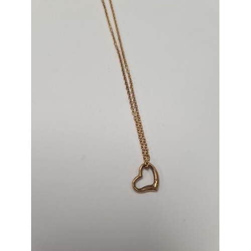 1058 - 18ct yellow gold fine neckchain hung with a 9ct gold heart pendant, marked 375, chain marked 750, ap... 