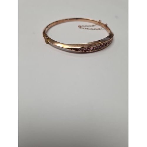 1008 - Antique 9ct yellow gold hinged bracelet with row of graduating garnets, and small diamond clips, app... 