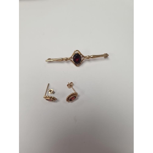 1047 - 9ct yellow gold bar brooch with oval garnet, marked 375, and pair of garnet earrings, unmarked