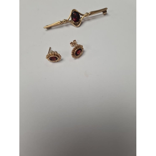 1047 - 9ct yellow gold bar brooch with oval garnet, marked 375, and pair of garnet earrings, unmarked