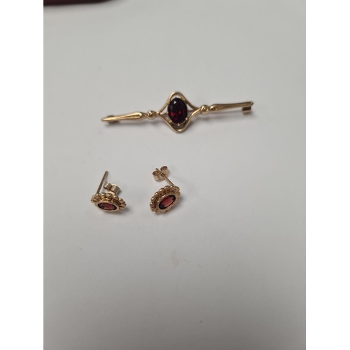 1047 - 9ct yellow gold bar brooch with oval garnet, marked 375, and pair of garnet earrings, unmarked