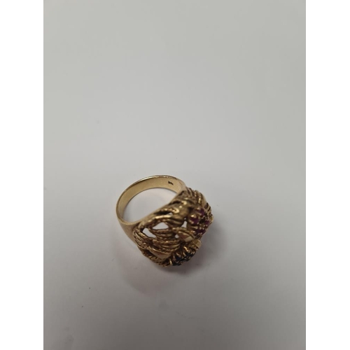 1073 - 18K yellow gold dress ring of decorative form, two flower heads, one inset rubies the other sapphire... 