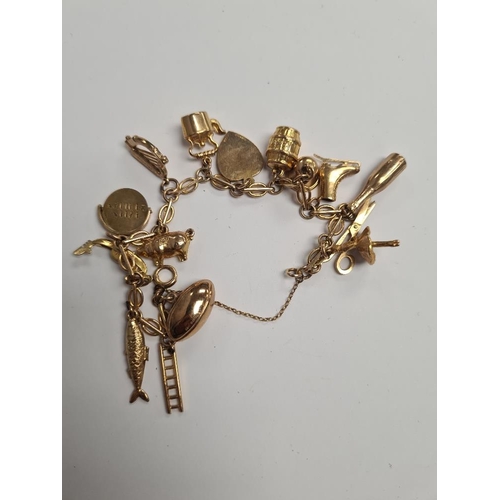 1096 - 9ct gold fancy link bracelet hung with 15 9ct gold charms to incl, ballerina, harp, pig, salmon, gon... 