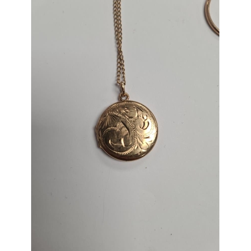 1113 - 9ct yellow gold fine neckchain hung with a circular locket, marked 375, the front engraved decoratio... 