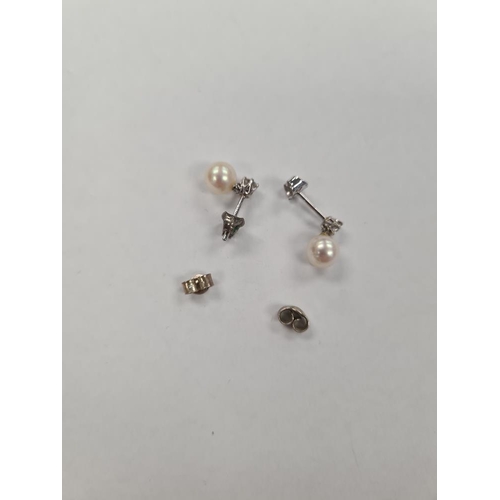 1128 - 18ct white gold stud drop earrings each with brilliant round cut diamond above a pearl, marked 750, ... 