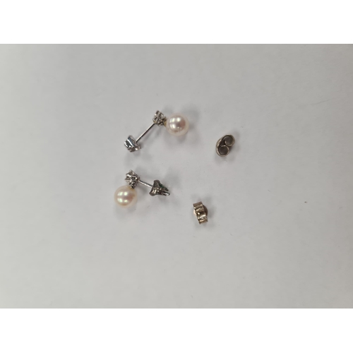 1128 - 18ct white gold stud drop earrings each with brilliant round cut diamond above a pearl, marked 750, ... 