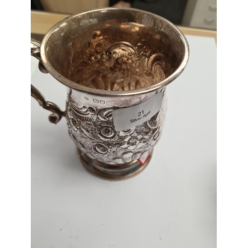 21 - A superb silver Edwardian tankard having heavily embossed bulbous body on a raised circular pedestal... 