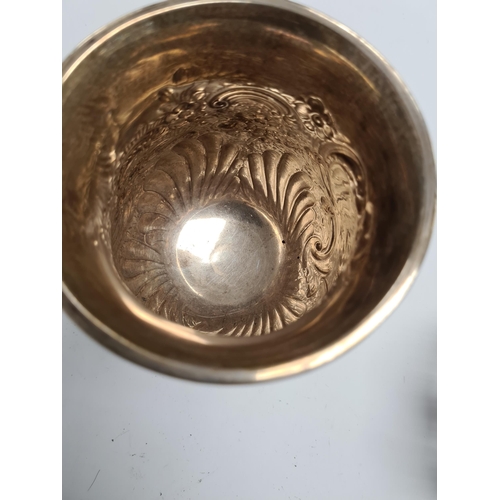 21 - A superb silver Edwardian tankard having heavily embossed bulbous body on a raised circular pedestal... 