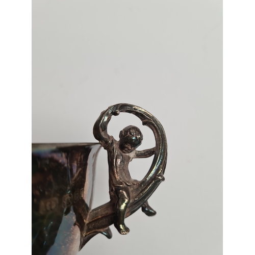 24 - An attractive silver two handled bowl with gilt interior. The handles each having a figure sat on a ... 