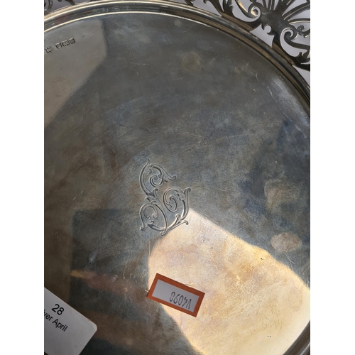 28 - A beautiful Edwardian silver tray of circular form, having pierced decorative border, four scroll fe... 