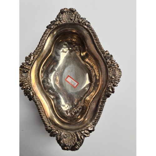 29 - A very heavy silver Georgian bowl, on a pedestal foot, with two handles and gadrooned and foliate em... 