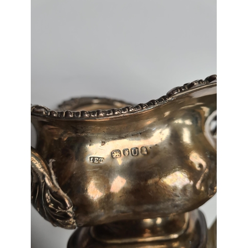29 - A very heavy silver Georgian bowl, on a pedestal foot, with two handles and gadrooned and foliate em... 