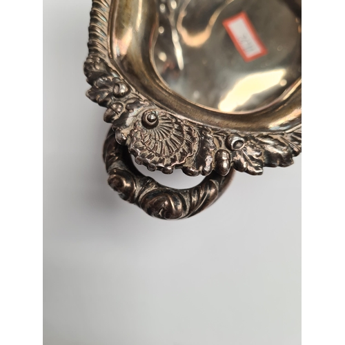 29 - A very heavy silver Georgian bowl, on a pedestal foot, with two handles and gadrooned and foliate em... 