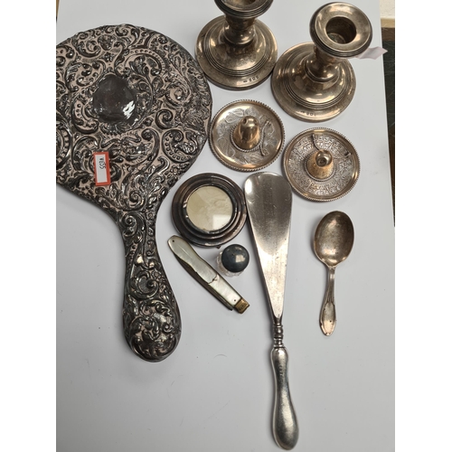 39 - A silver heavily embossed back mirror. Hallmarked Birmingham 1912, W J Myatt and Co. A pair of minia... 