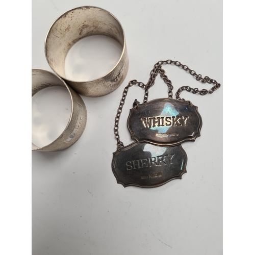 46 - Silver decanter labels for 'Whisky' and 'Sherry'. Also with a pair of silver engine turned napkin ri... 