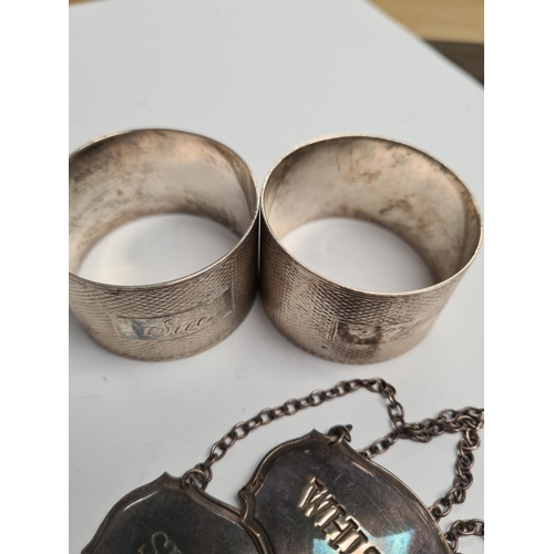 46 - Silver decanter labels for 'Whisky' and 'Sherry'. Also with a pair of silver engine turned napkin ri... 